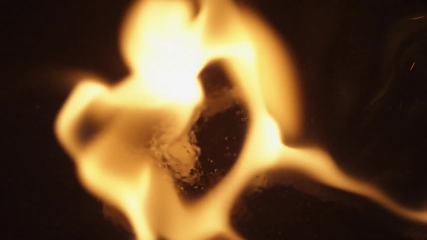A close up view of gas being ignited by sparks on a black surface
