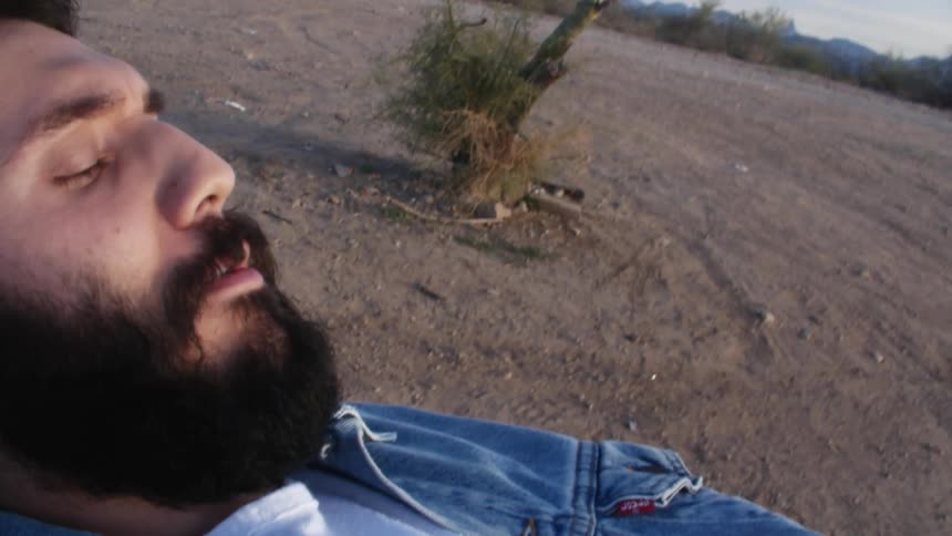 A man smoking and laying on his back