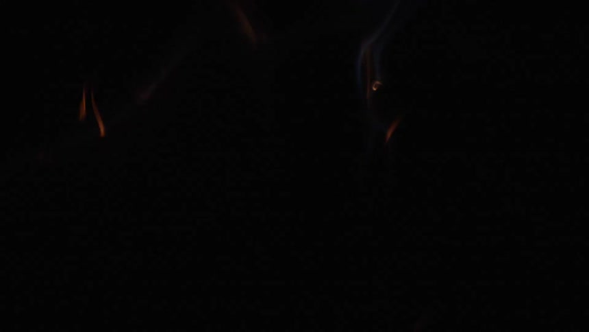 sparks explode and ignite a fire on a black surface