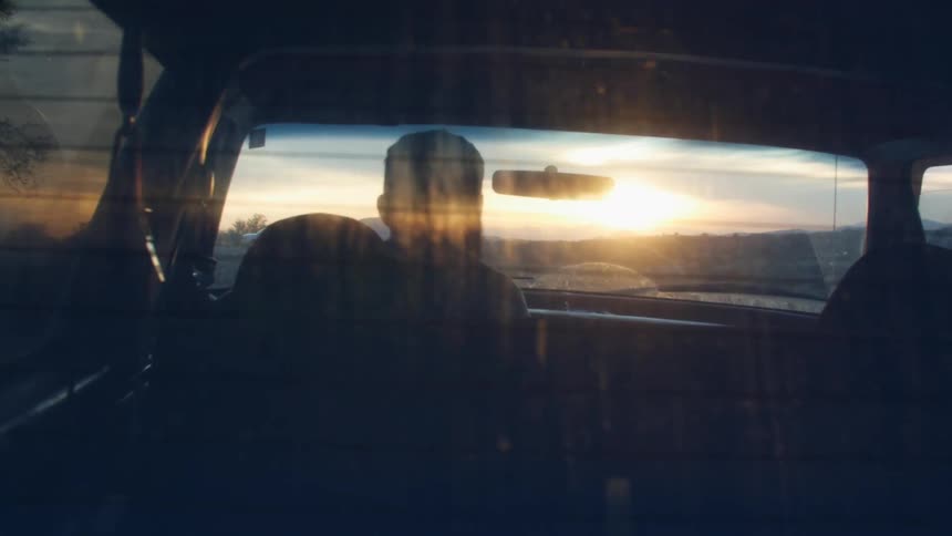 A man enters the drivers seat of a parked vehicle and closes the door