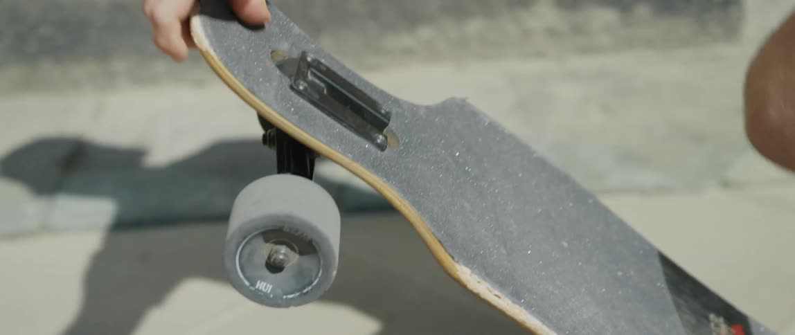 A man riding a skateboard outside on concrete