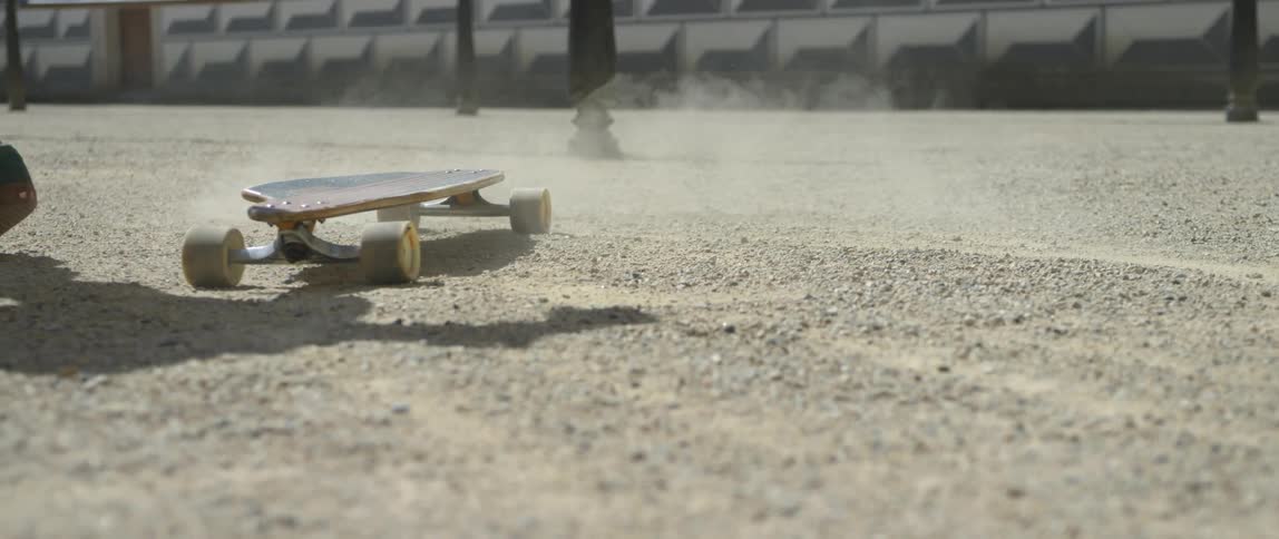 Person stops skateboard before walking off as pedestrian walks by