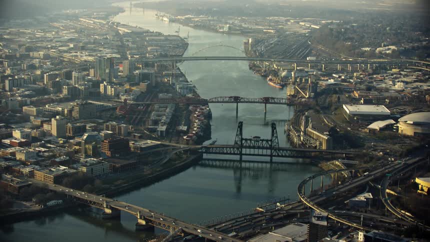 Gritty aerial of the Burnside bridge, Steel Bridge and Freemont bridge spanning the Willamette River in downtown Portland Oregon