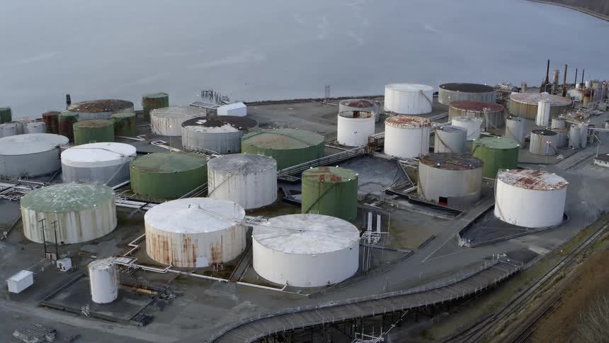 Slow push toward a maze of chemical and oil tanks along coastal waterfront