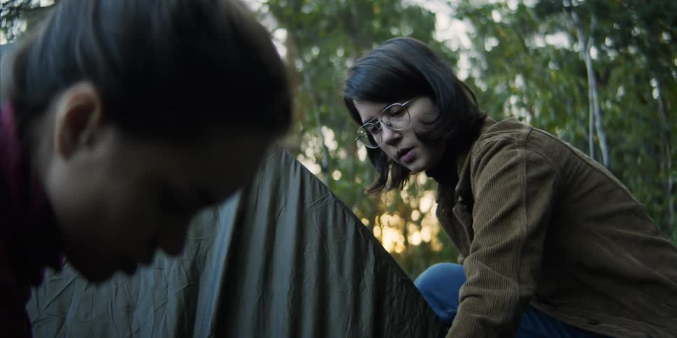 Two women set up a tent together