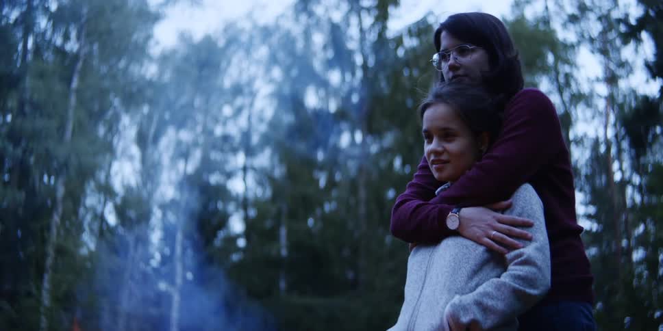 Two women hug near the fire