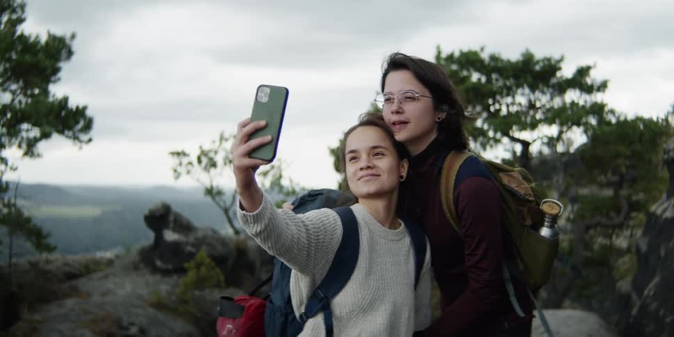 Two women take a selfie together on the mountain top