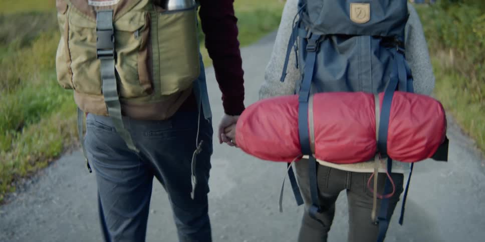 Two women hold hands while hiking