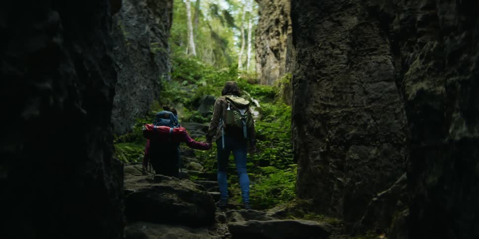 Two women are hiking through a forest