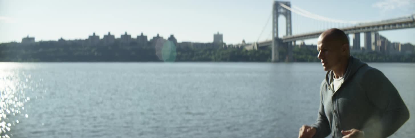 A man is jogging outdoors near the ocean