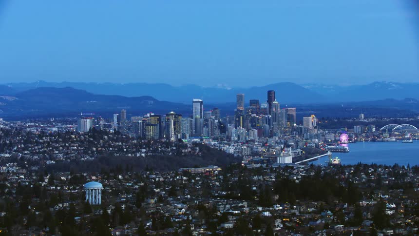 Wide Aerial shot of downtown Seattle after the sun has set showing Elliott Bay, Washington State Ferries and beautiful neighborhoods on the outskirts of Seattle