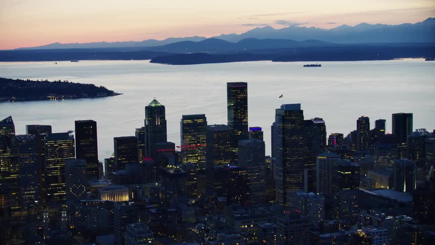 Downtown Seattle and the Purget Sound glow beautifully in this awesome aerial of the city just after the sun set in the blue hour light
