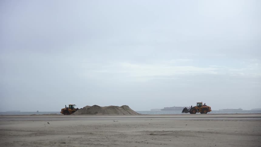 Two bulldozers parked on the beach