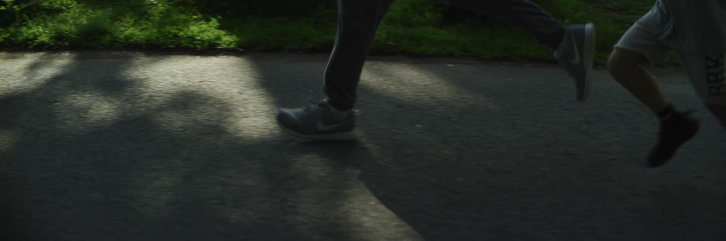 Father and son jogging on a park in the morning