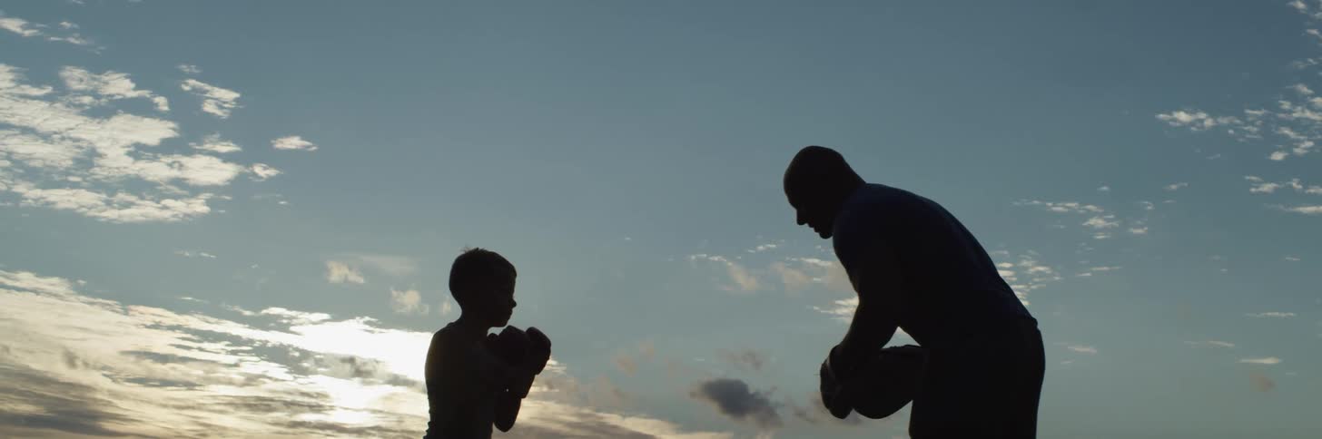 A father and son boxing outdoors