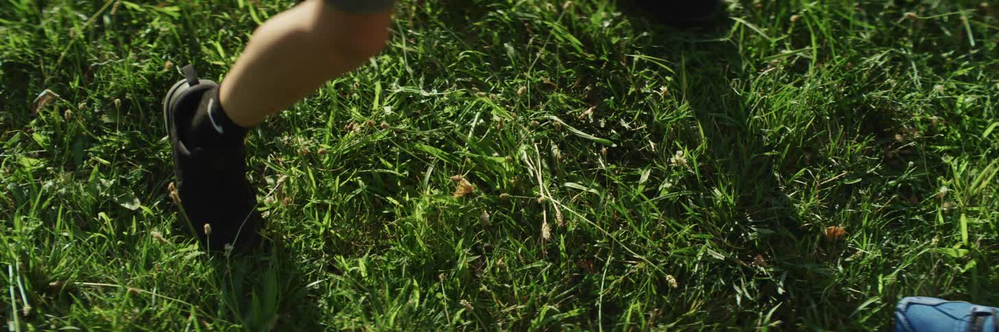 Two people standing on green grass move