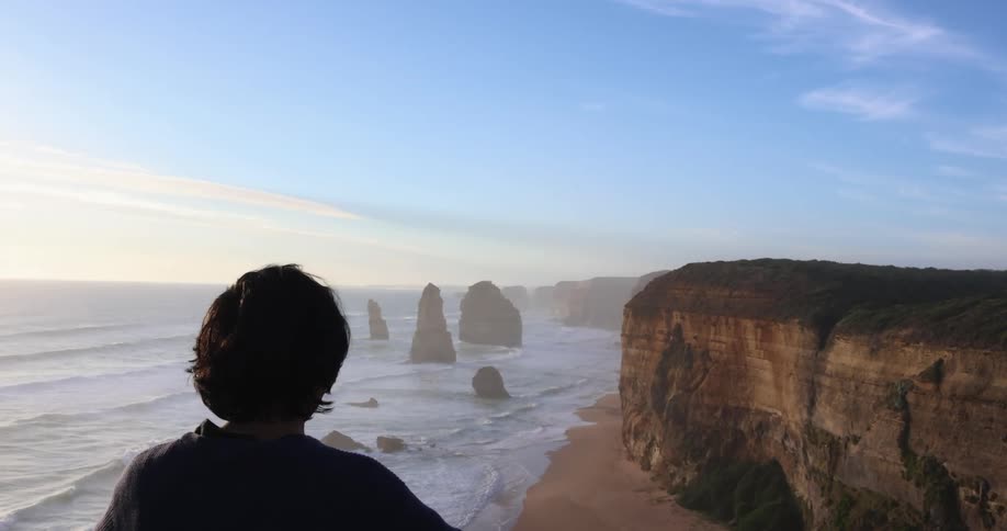 A person on the cliff is viewing the ocean