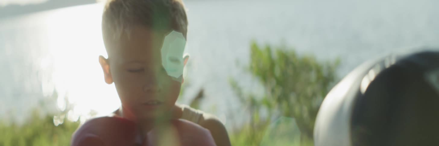 Sun glares off water behind boy training in boxing