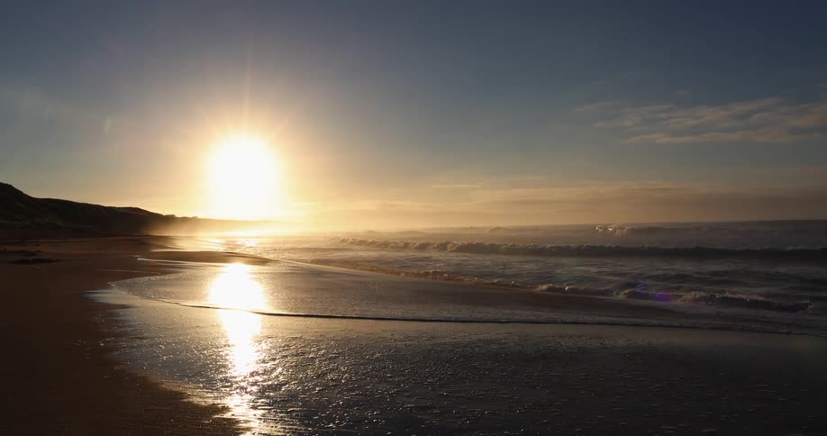 Waves rolling in to the shore as the sun sets