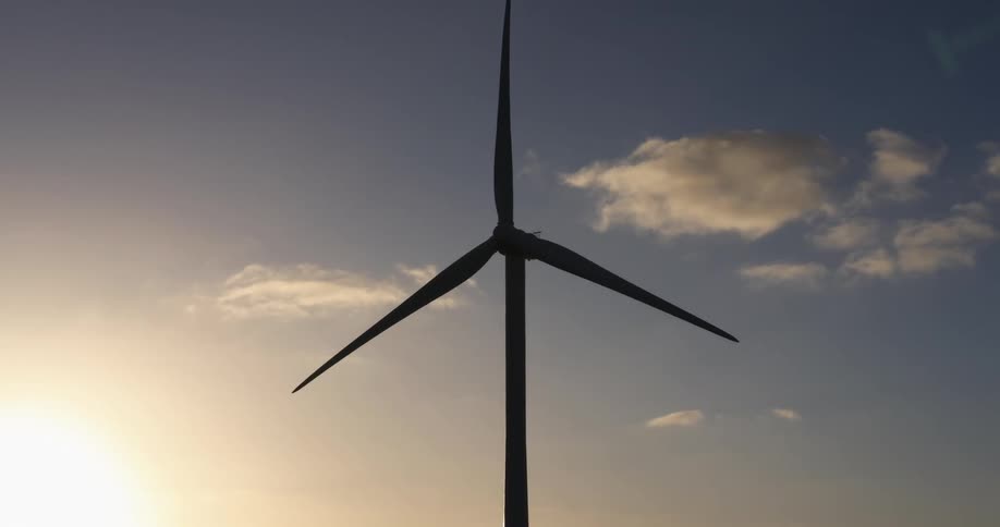The wind turbine turns in the sky