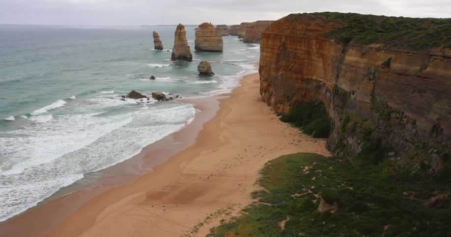 Waves rolling in to the shore with a large cliff on it