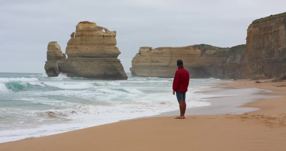 A man that is standing at the edge of the sea
