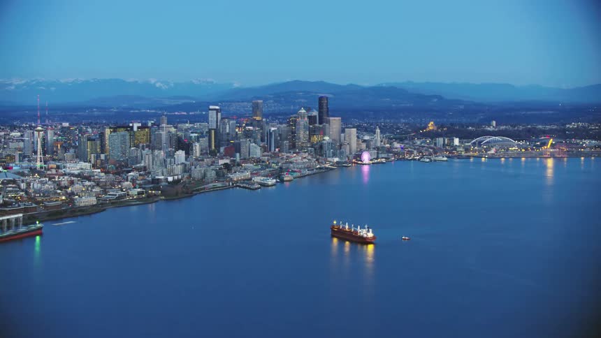 A freight ship waits in Elliott Bay outside of downtown Seattle in this beautiful post sunset blue hour hour of the city landscape