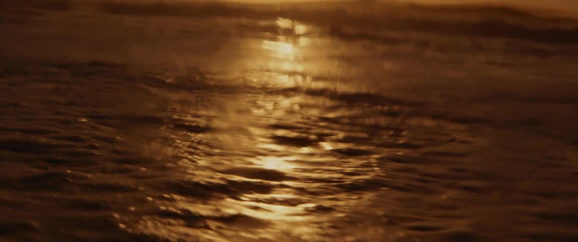 Waves crash onto the beach at sunset