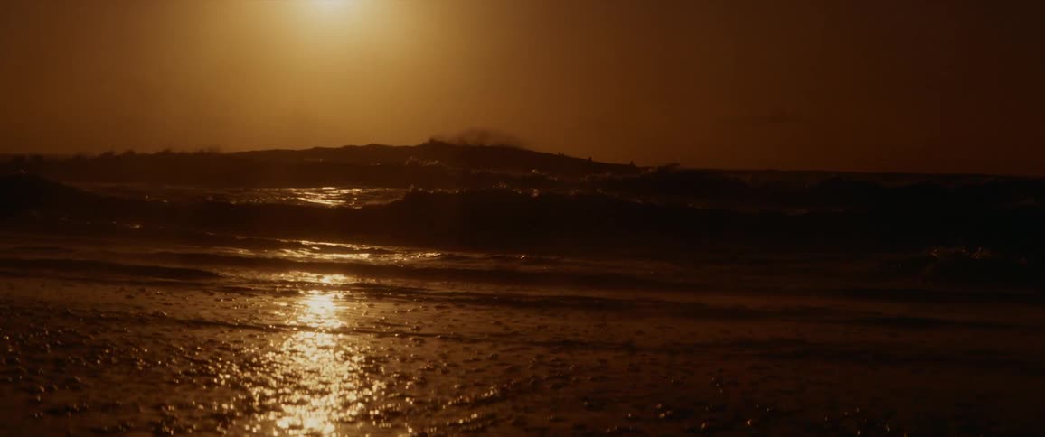 An ocean with waves of water with a sunset the sky and clouds in the background