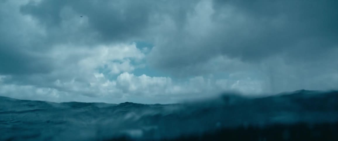 The ocean waves roll and splash on a cloudy day
