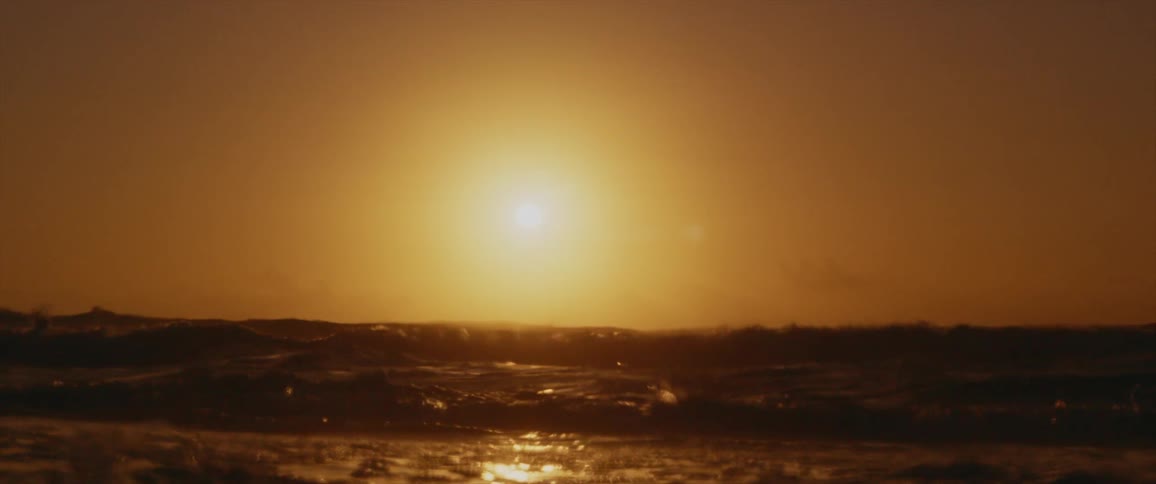 An ocean with waves of water with a sunset the sky and clouds in the background