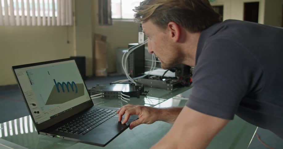 A man in an office looks at a laptop