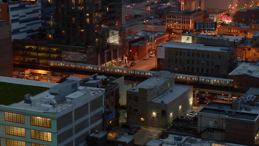 An elevated train travels over Chicago streets at night