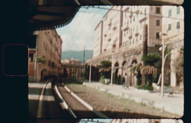 Train tracks on a narrow road through a city