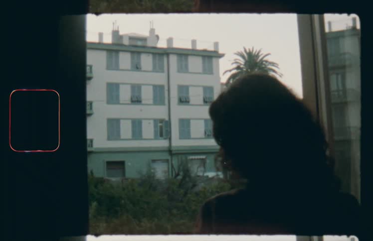 Woman opens curtains and windows to look outside