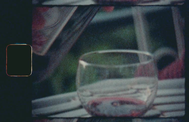 A white person pours a glass of wine outdoors