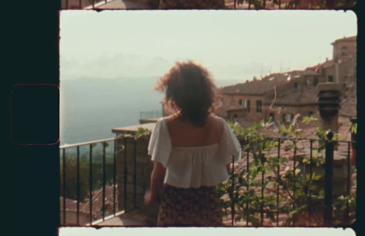 A woman is standing on the terrace on a windy day