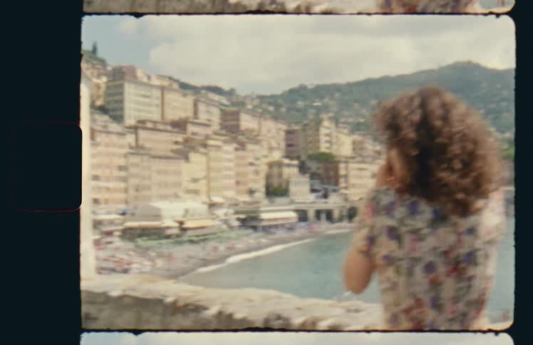 A woman by a beach resort takes pictures with her camera