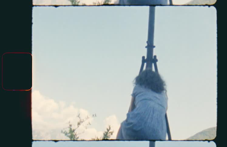 A woman climbs up a wall and raises her hands in the air
