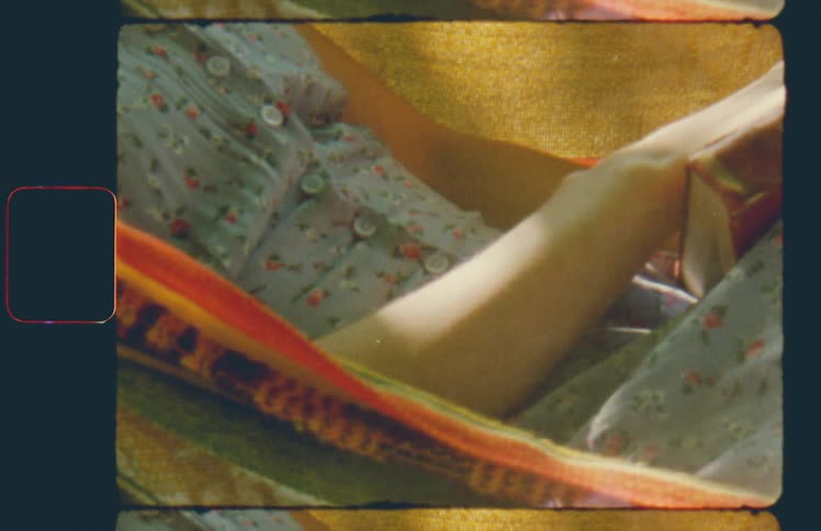A woman in a floral pattern dress lying in an outdoor hammock while holding a book