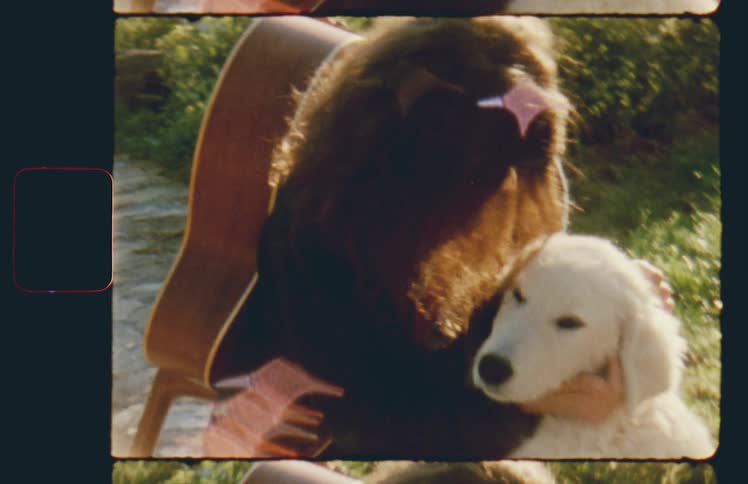 A woman with a guitar on her back pets a dog