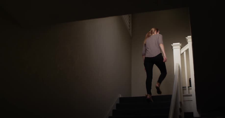 A blonde woman walks up the stairs