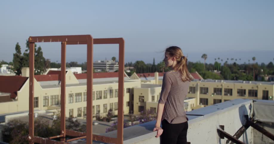 Woman standing on a rooftop and looking outward
