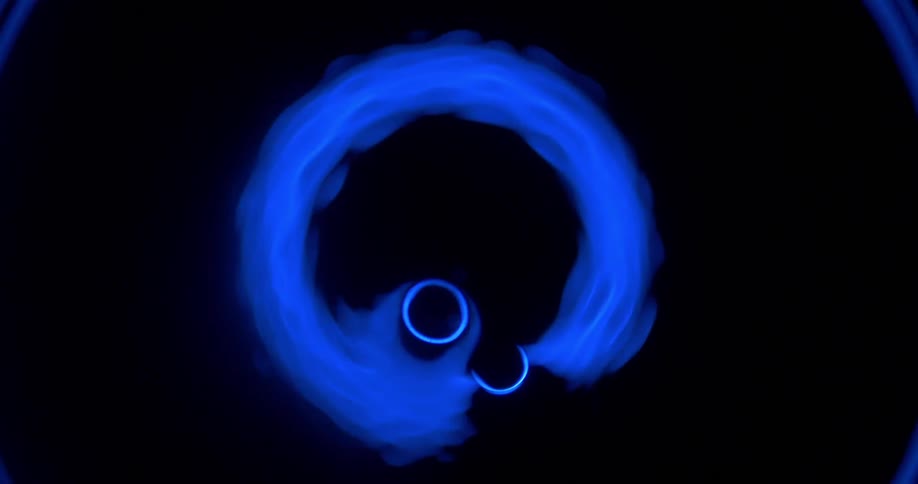 Bright blue light glows and vibrates then explodes against a black background