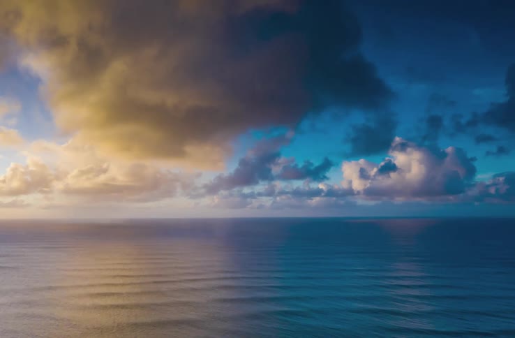 Clouds reflecting on the water as they move over an ocean