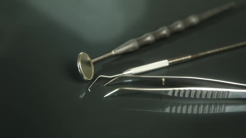 Dental tools lying on a reflective surface