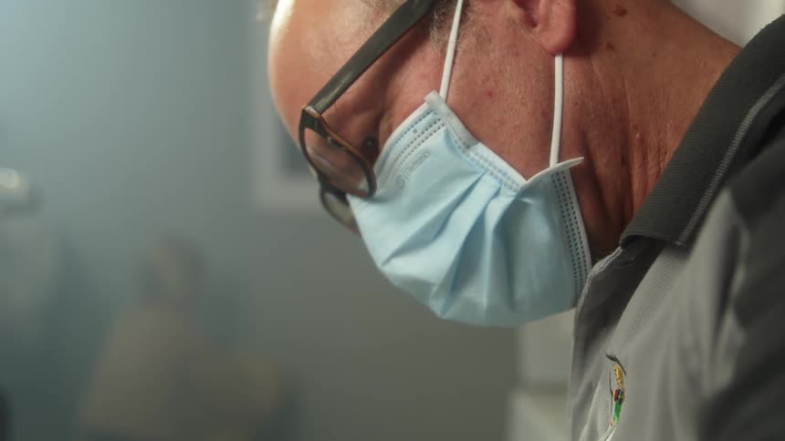 A man wearing a mask looks down