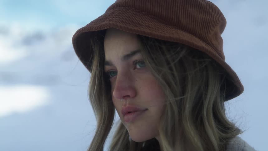 A young woman in a hat standing outside in winter