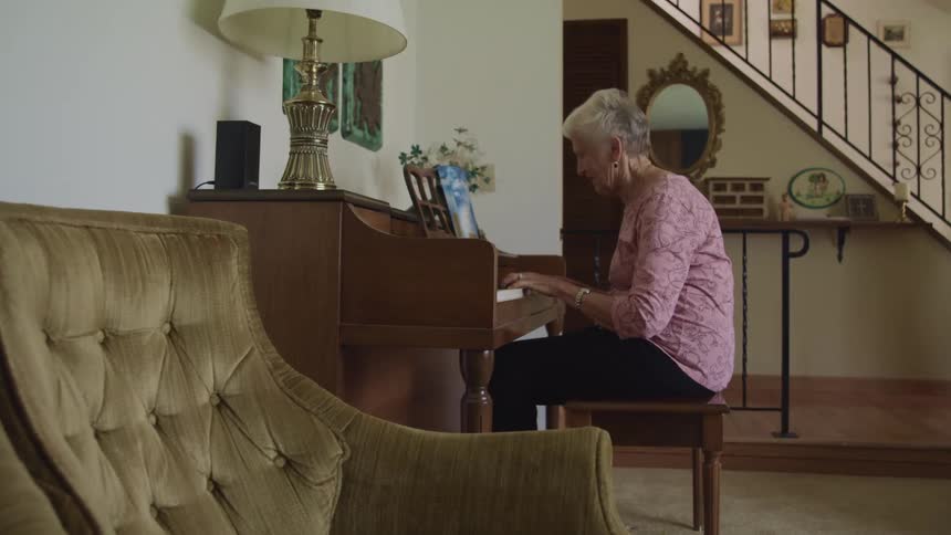 A woman is playing the piano at home