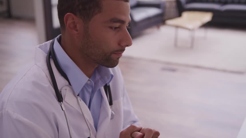 Male doctor with a stethoscope and a white coat nods his head in the clinic